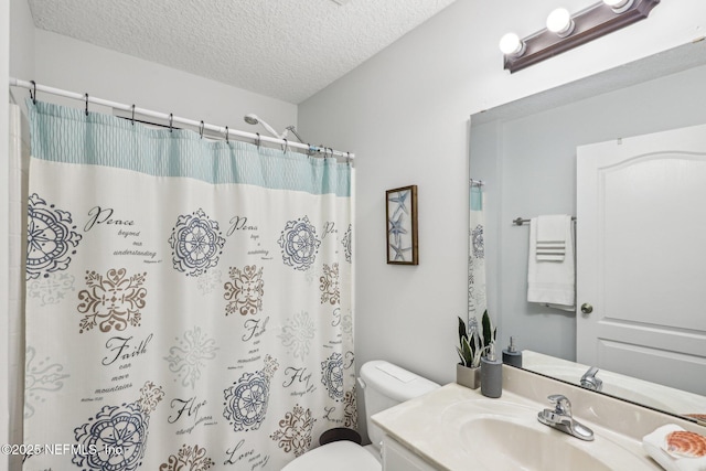 bathroom with a shower with curtain, vanity, toilet, and a textured ceiling