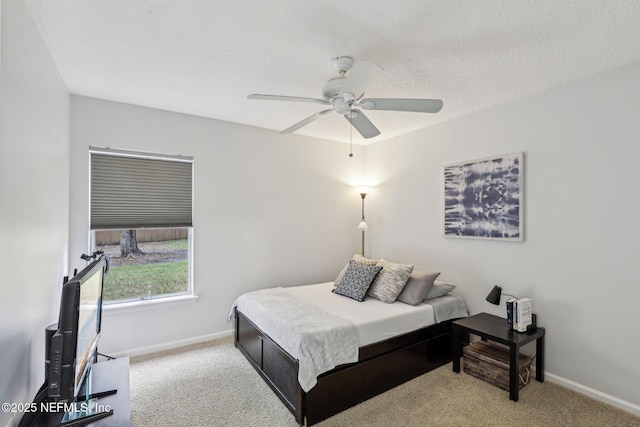 bedroom featuring ceiling fan, light carpet, and a textured ceiling