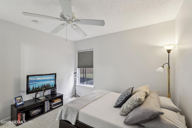 bedroom with ceiling fan, a textured ceiling, and carpet flooring