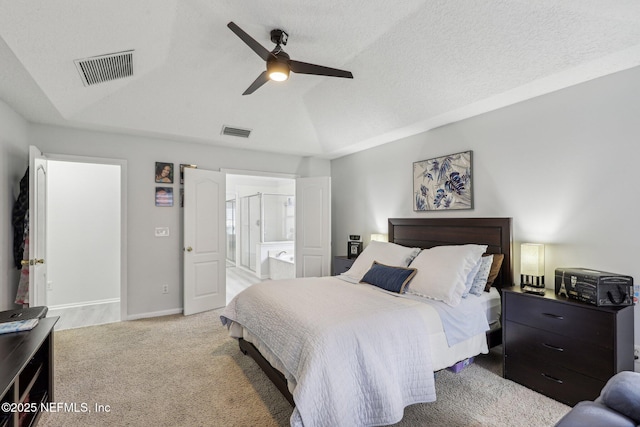 carpeted bedroom featuring ceiling fan, vaulted ceiling, a textured ceiling, and ensuite bathroom