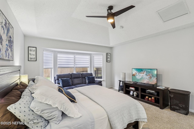 bedroom with ceiling fan, vaulted ceiling, light carpet, and a textured ceiling