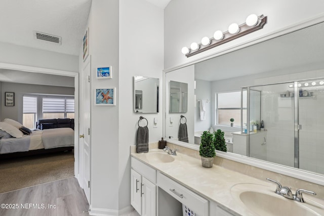 bathroom featuring vanity, a healthy amount of sunlight, hardwood / wood-style floors, and an enclosed shower