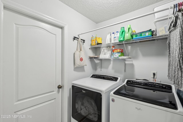 laundry area with separate washer and dryer and a textured ceiling