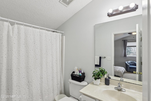 bathroom with vanity, a textured ceiling, vaulted ceiling, toilet, and walk in shower