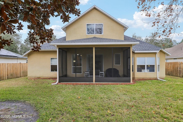 back of property with a sunroom and a lawn