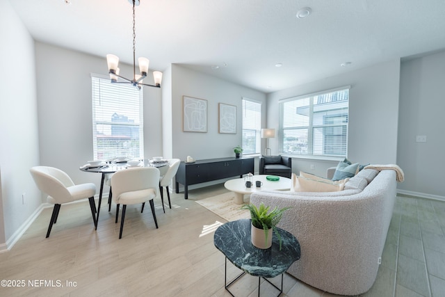 living room featuring a notable chandelier and light wood-type flooring