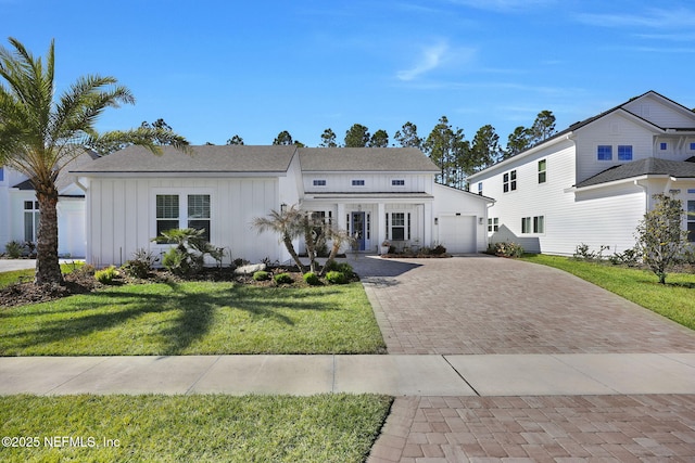 view of front of home with a front yard and a garage