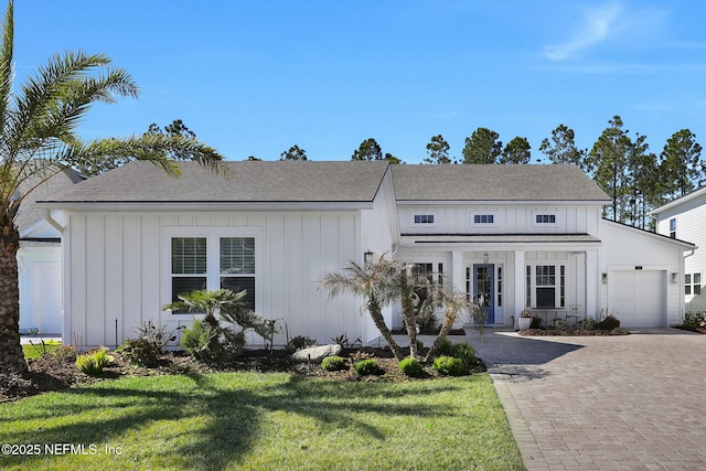 modern inspired farmhouse featuring a garage and a front yard