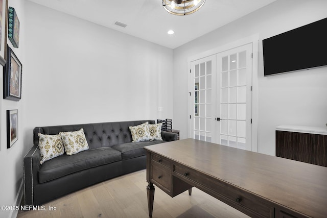 living room with light wood-type flooring and french doors