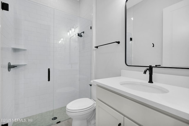 bathroom with toilet, vanity, and a shower with door