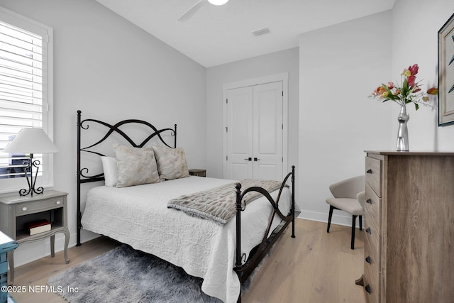 bedroom with hardwood / wood-style flooring, ceiling fan, and a closet