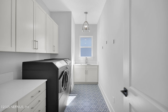 laundry area featuring cabinets, sink, separate washer and dryer, and a textured ceiling