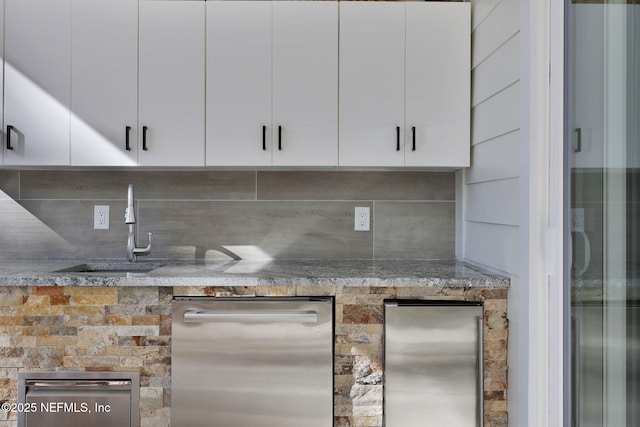 kitchen with white cabinetry, stainless steel fridge, and decorative backsplash