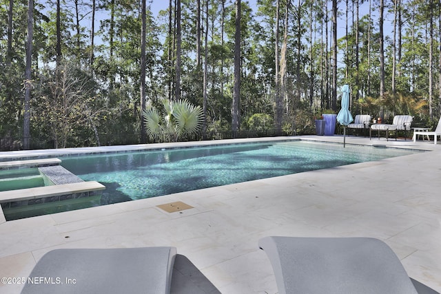 view of swimming pool with a patio area and an in ground hot tub