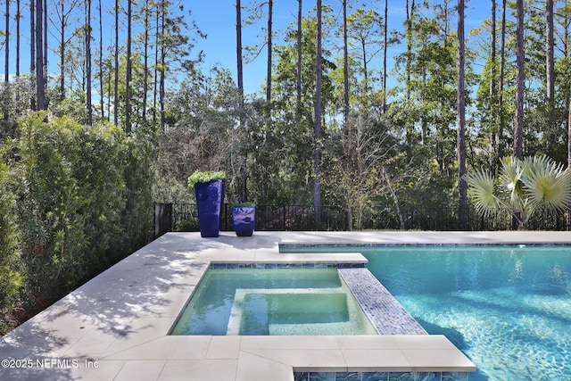 view of swimming pool with an in ground hot tub