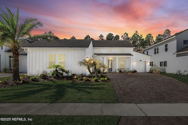 view of front of home with a garage and a lawn