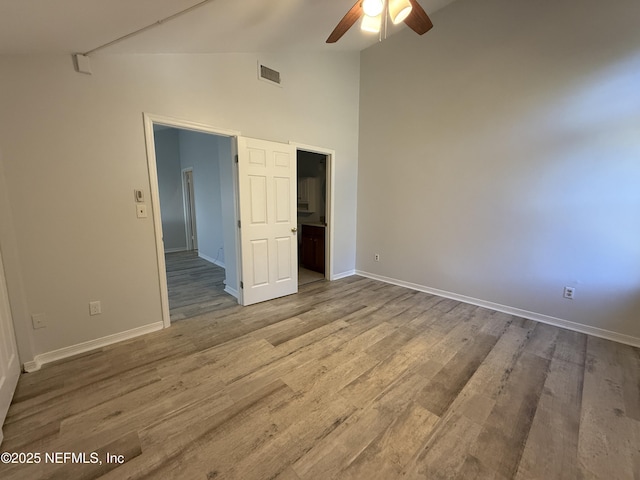 unfurnished room with hardwood / wood-style flooring, vaulted ceiling, and ceiling fan