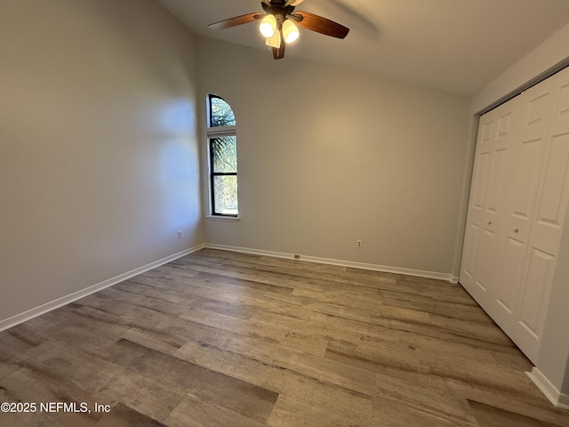 unfurnished bedroom with hardwood / wood-style floors, a closet, and ceiling fan