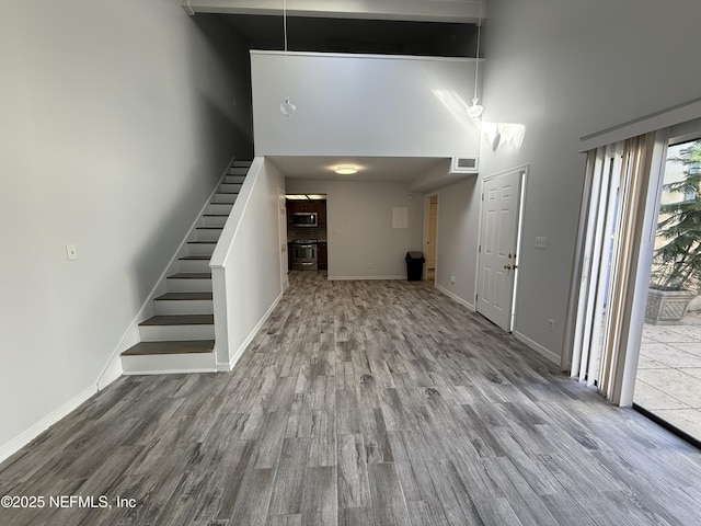 interior space featuring a high ceiling and hardwood / wood-style flooring