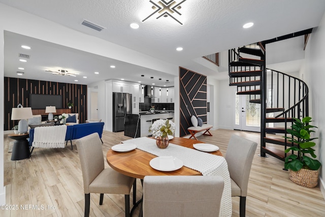 dining space featuring a textured ceiling and light hardwood / wood-style flooring