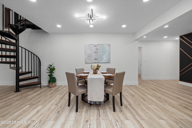 dining room with a textured ceiling and light wood-type flooring