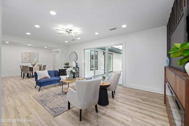 living room featuring light hardwood / wood-style flooring and a textured ceiling