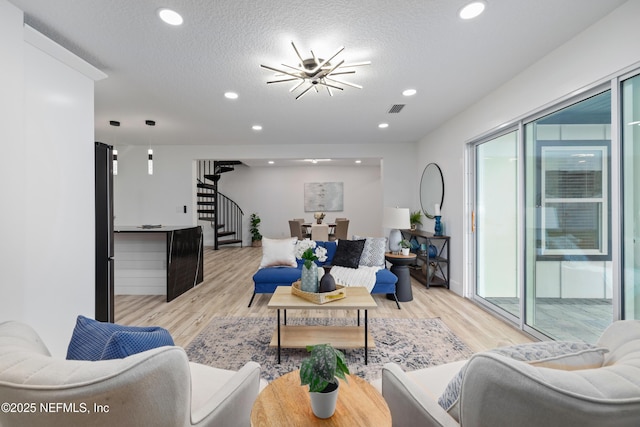 living room with light wood-type flooring and a textured ceiling