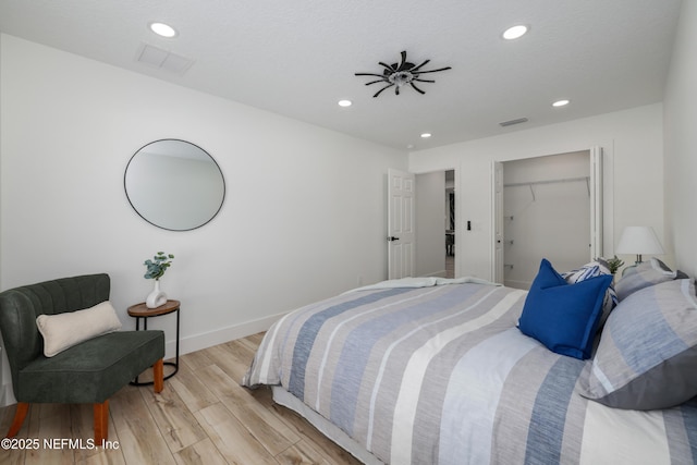 bedroom with light hardwood / wood-style floors, a closet, and a textured ceiling