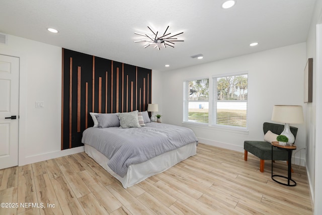 bedroom with a notable chandelier and light hardwood / wood-style floors