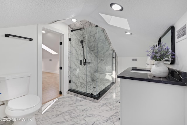 bathroom featuring walk in shower, vanity, a textured ceiling, and toilet