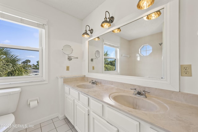 bathroom featuring tile patterned floors, toilet, vanity, and a textured ceiling