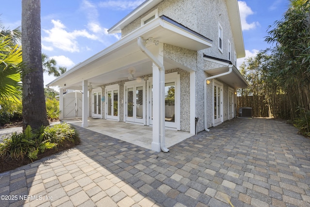 view of property exterior featuring french doors, ceiling fan, a patio area, and central air condition unit