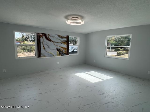 unfurnished room featuring a textured ceiling