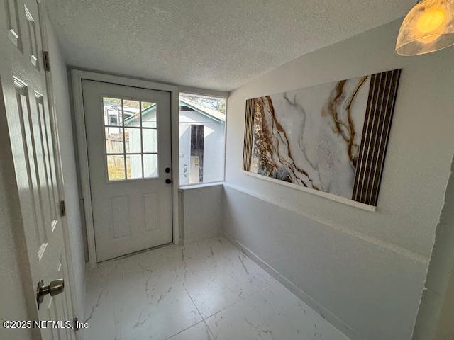 entryway with lofted ceiling and a textured ceiling