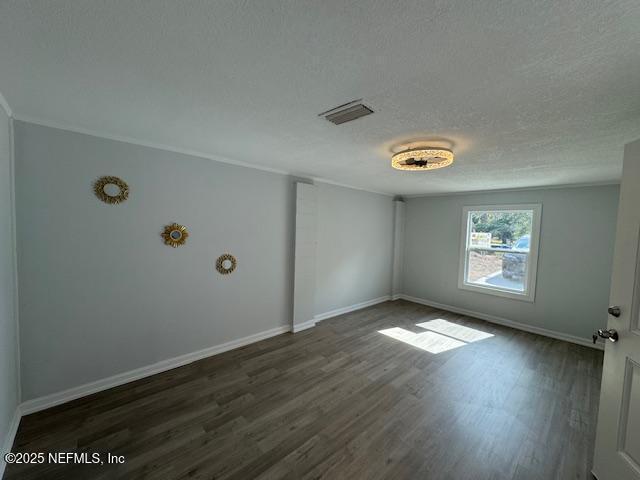 empty room featuring dark hardwood / wood-style floors and a textured ceiling