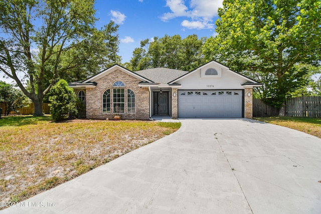 ranch-style home with a garage and a front lawn