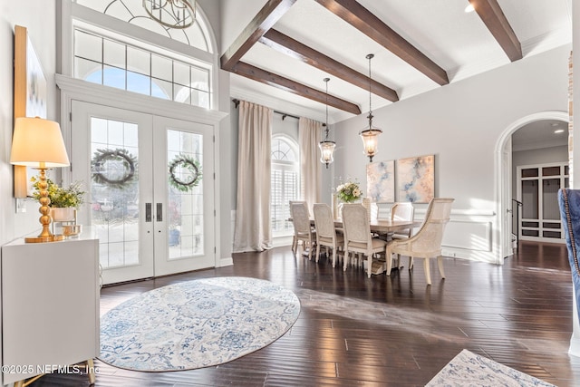 foyer with dark hardwood / wood-style floors, beam ceiling, and french doors