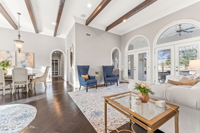 living room featuring beamed ceiling, a towering ceiling, dark wood-type flooring, and french doors