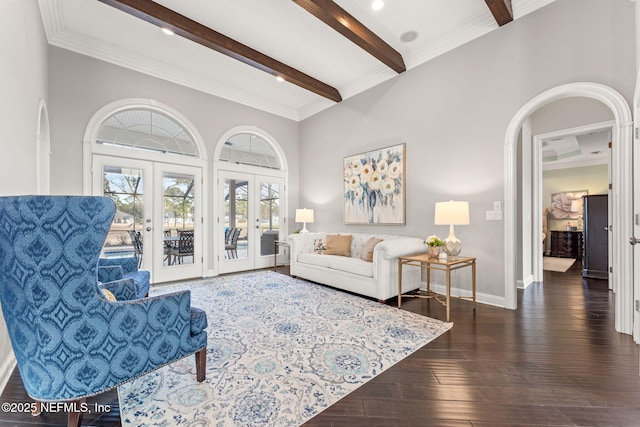 living room with french doors, dark wood-type flooring, ornamental molding, a towering ceiling, and beam ceiling