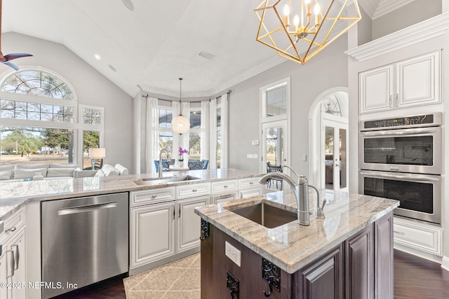 kitchen featuring sink, light stone countertops, hanging light fixtures, and appliances with stainless steel finishes