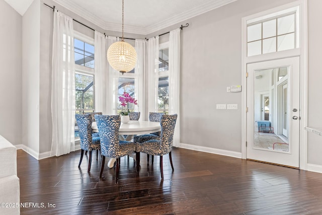 dining room featuring a towering ceiling, ornamental molding, dark hardwood / wood-style floors, and a wealth of natural light