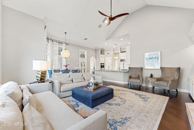 living room with ceiling fan, dark hardwood / wood-style flooring, and high vaulted ceiling