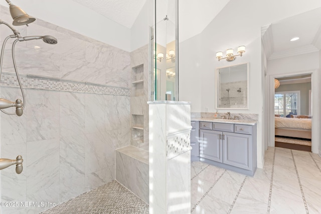 bathroom with tiled shower, vanity, and ornamental molding