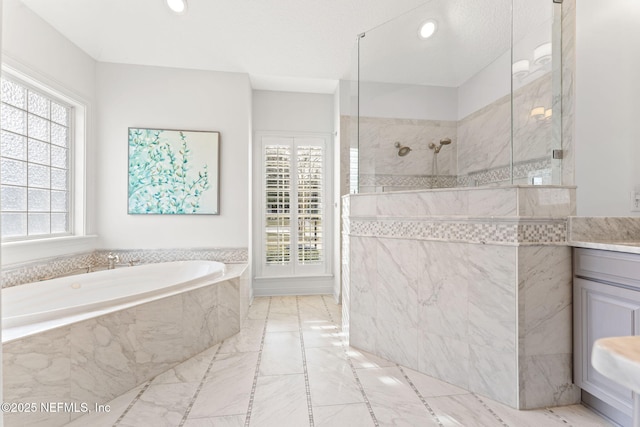 bathroom with vanity, shower with separate bathtub, and a wealth of natural light