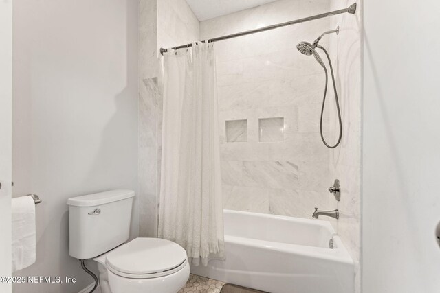 bathroom featuring toilet and shower / bath combo with shower curtain