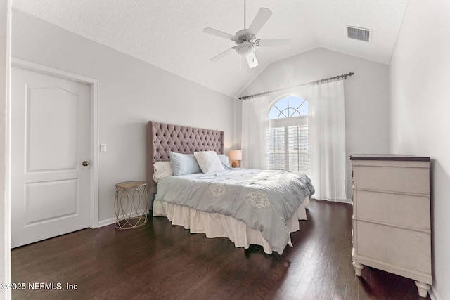 bedroom featuring dark hardwood / wood-style flooring, vaulted ceiling, and a textured ceiling