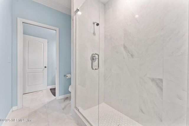 bathroom featuring a shower with shower door and toilet