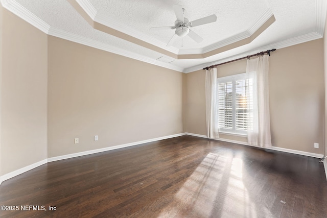 empty room with dark hardwood / wood-style floors, ceiling fan, a tray ceiling, and a textured ceiling