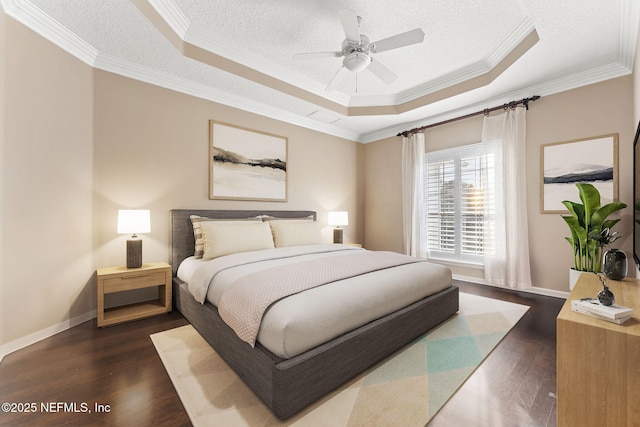 bedroom with crown molding, a tray ceiling, dark hardwood / wood-style floors, and a textured ceiling