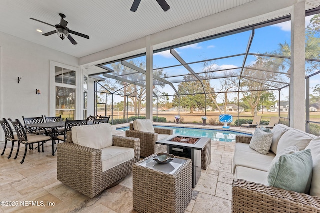 view of patio featuring ceiling fan, an outdoor living space, and a lanai